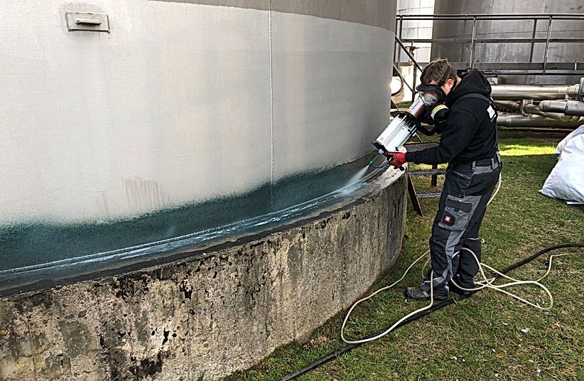 DSM-Techniker beschichtet einen Tanksockel vor Ort
